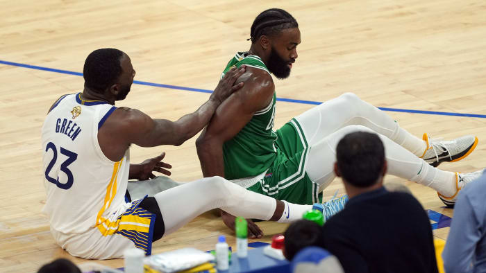 Boston Celtics guard Jaylen Brown (7) and Golden State Warriors forward Draymond Green (23) on the floor after a collision in the second half during game two of the 2022 NBA Finals.